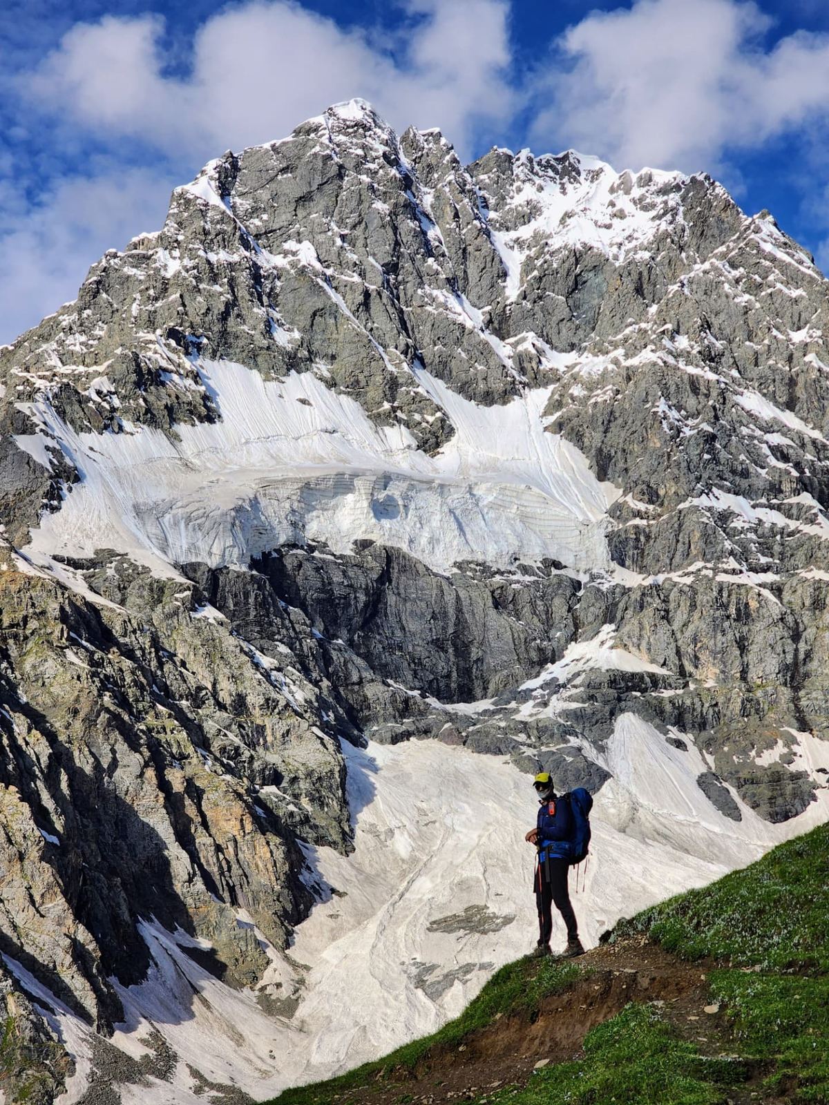 A mountaineer below a glaciated Karakoram peak